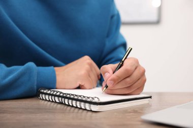 Kapalı bir masadaki dizüstü bilgisayarda yazan metin yazarı.