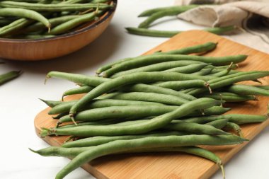 Beyaz masada taze bezelye kabukları, yakın plan.