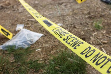 Adli tıp uzmanlığı. Kanıt, işaret ve polis bandı olan suç mahalli açık havada, kapalı.