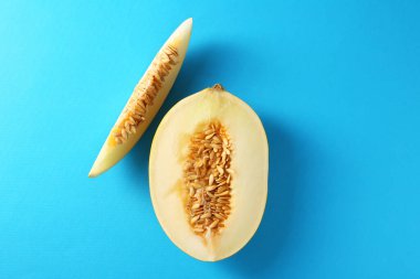 Açık mavi arkaplanda taze olgun kavun kes, düz uzan.
