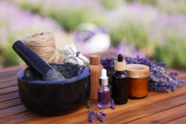 Doğal kozmetik ürünleri yapıyorum. Ahşap masadaki güzel lavanta çiçekleri ve diğer malzemeler. Yakın plan.