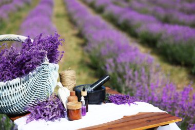 Doğal kozmetik ürünleri yapıyorum. Güzel lavanta çiçekleri ve ahşap masa üzerindeki diğer malzemeler.