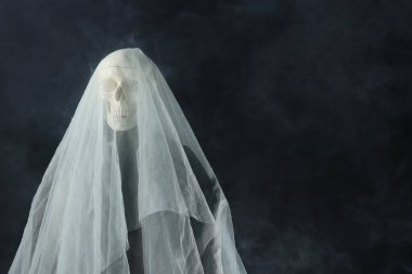 Ürkütücü hayalet. Siyah arkaplanda beyaz bir çarşaf, metin için boşluk