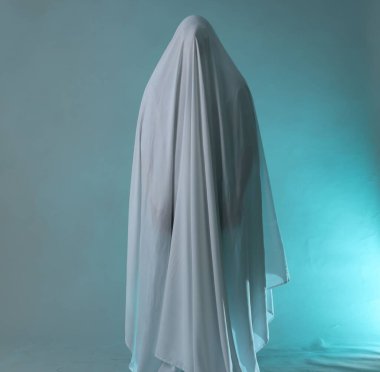 Ürkütücü hayalet. Açık mavi arka planda dumanla kaplı beyaz çarşaflı adam.