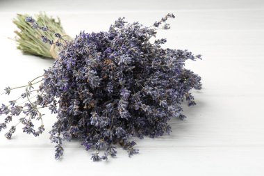 Beyaz ahşap masada lavanta çiçeği demeti, yakın plan.