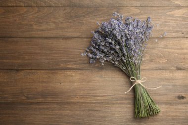 Ahşap masanın üzerinde bir demet aromatik lavanta çiçeği, üst manzara. Metin için boşluk