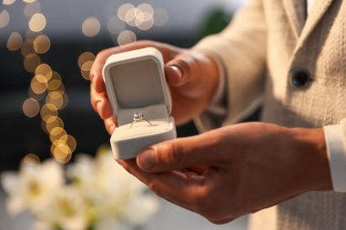Evlenme teklif ediyorum. Nişan yüzüklü adam içeride, yakın plan. Bokeh etkisi