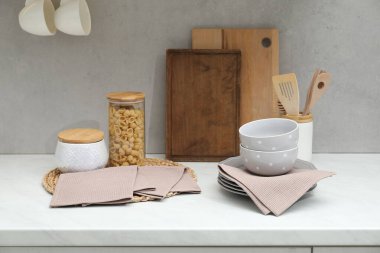 Temiz bulaşık takımı, waffle havluları ve mutfak tezgahında çiğ makarna.