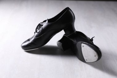 Beyaz tahta zeminde step dansı için bir çift ayakkabı.