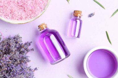 Aromatik gerekli yağ, deniz tuzu ve mor arka planda lavanta çiçekleri, düz yatıyordu.
