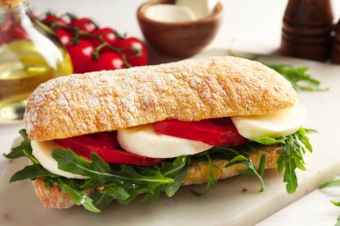 Peynirli, domatesli ve roka soslu lezzetli bir sandviç.