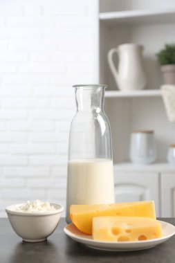 Mutfaktaki gri desenli masada farklı süt ürünleri.