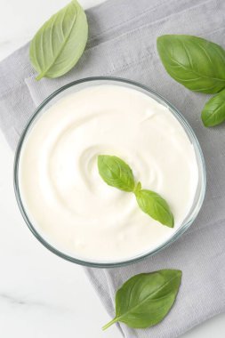Lezzetli yoğurt ve fesleğen beyaz masada, düz yerde.