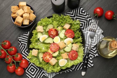 Siyah masa üzerinde kızarmış ekmek ve malzemelerle nefis bir salata.