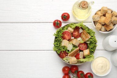 Lezzetli salata, kızarmış ekmek ve beyaz ahşap masa üzerindeki malzemeler, düz yatak. Metin için boşluk