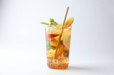 Limonlu buzlu çay, beyaz arka planda şeftali ve nane.