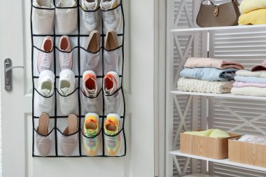 Kapısında farklı ayakkabılar ve içeride giysi olan bir organizatör. Ayakkabı deposu