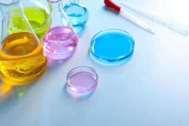 Işık masasında farklı numunelerle laboratuvar camları, yakın plan.