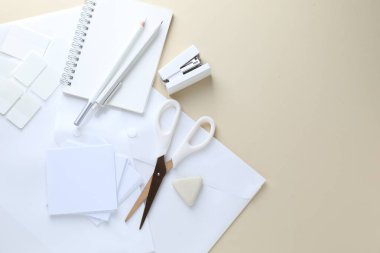 Bej arka planda beyaz kırtasiye malzemesi, düz. Metin için boşluk