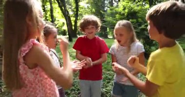 Parkta taş, kağıt ve makas oynayan sevimli çocuklar.