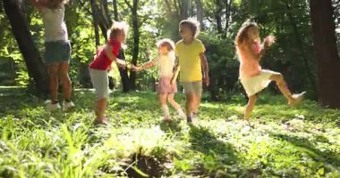 Küçük şirin çocuklar parkta birlikte eğleniyorlar.