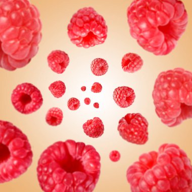 Bej arka planda havada dönen taze ahududular.