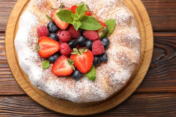 Tahta masada pudra şekeri ve böğürtlenli Lezzetli kek.