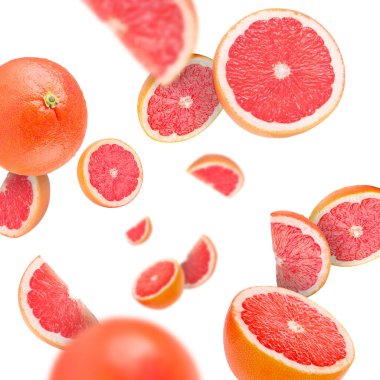 Beyaz arka planda taze greyfurtlar uçuşuyor.