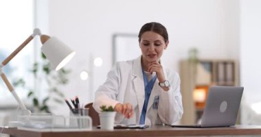 Teletıp. Bilgisayarla hastayla video görüşmesi sırasında not alan doktor.