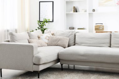 Aydınlık oturma odasında yumuşak bir kanepe. İç tasarım