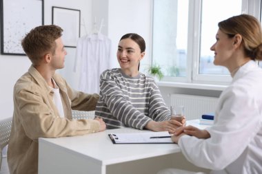 Tüp bebek (tüp bebek). Mutlu çiftin üreme kliniğinde doktorla randevusu var.