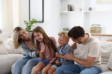 Mutlu aile evdeki kanepede eğleniyor.