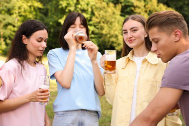 Bir grup mutlu arkadaş dışarıda bira içip eğleniyorlar.