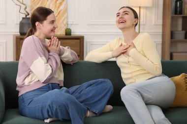 Arkadaşlar kanepede gülüyor. Pozitif duygu