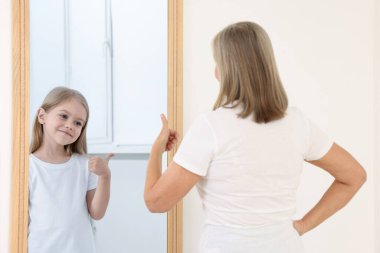 Yaşlı kadın kendini aynada çocuk olarak görüyor. Geçmiş ve gelecek hakkında kavramsal kolaj, zaman akışı, yaş