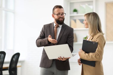 Ofiste dizüstü bilgisayarla çalışan iş ortakları