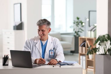 Teletıp. Doktor içeride bilgisayarla hastayla görüntülü konuşma yaparken not alıyor.