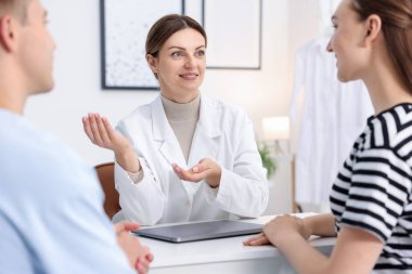 Tüp bebek (tüp bebek). Üreme kliniğinde doktorla randevusu olan çift, seçici odaklanma