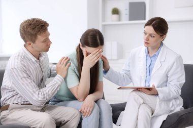 Tüp bebek (tüp bebek). Üreme kliniğinde doktorla randevusu olan üzgün çift.