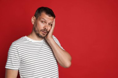 Kırmızı arka planda akşamdan kalma bir adam, metin için boşluk