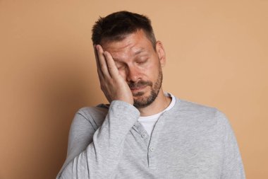 Bej arka planda akşamdan kalma bir adam.