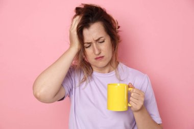 Bir fincan kahveli kadın pembe arka planda akşamdan kalma.