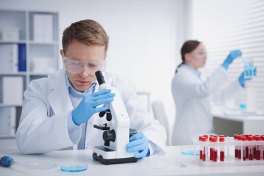 Tıbbi analiz. Laboratuvarda numunelerle çalışan bilim adamları, seçici odaklanma