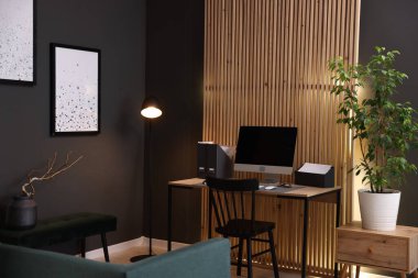 Ahşap masalı ve bilgisayarlı şık bir iş yeri.