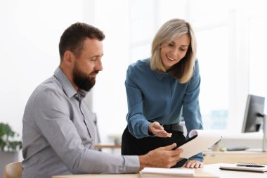 Ofisteki belgelerle çalışan gülümseyen iş ortakları