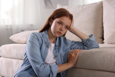 Panik atak geçiren genç kız evdeki kanepede uzanıyor.