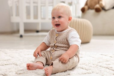 Işık odasında halının üzerinde oturan tatlı bebek.