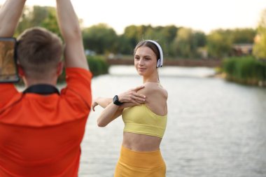 Güzel nehrin kenarında sabah egzersizi yapan çift.