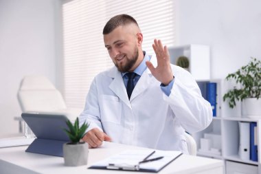 Doktor içeride tabletle çevrimiçi danışmanlık yapıyor.