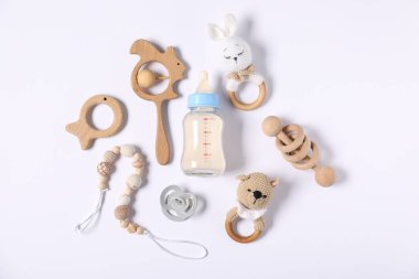 Besleme şişesi ve hafif arka planda bebek aksesuarları.